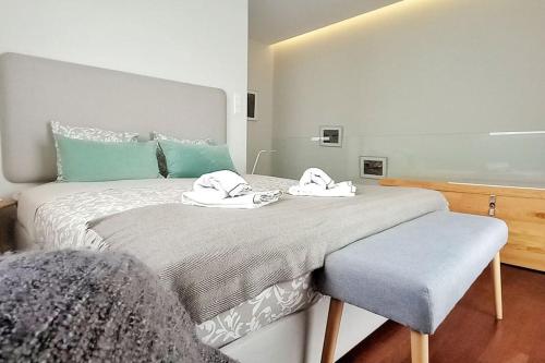 a bedroom with a large bed with towels on it at Typical Quarter Nest in Porto