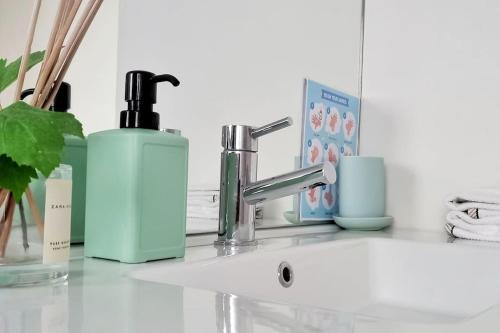 a bathroom sink with a bottle of soap and a soap dispenser at Typical Quarter Nest in Porto
