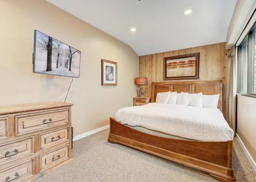 a bedroom with a bed and a dresser and a window at Silver King by All Seasons Resort Lodging in Park City