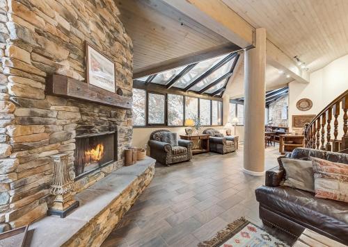 a living room with a large stone fireplace at Silver King by All Seasons Resort Lodging in Park City