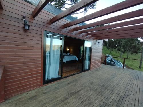 a deck with a view of a bedroom at Monte Alegre Pousada in São Joaquim