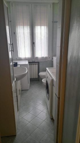 y baño con lavamanos y lavadora. en CASA DEL BORGO, en San Venanzio