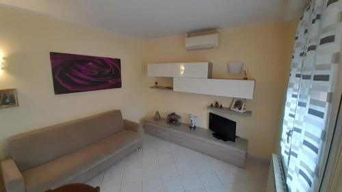 sala de estar con sofá y TV en CASA DEL BORGO, en San Venanzio