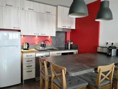 une cuisine avec des armoires blanches et une table et des chaises dans l'établissement Appartement rénové 2 ch au calme, à côté du Luge Park - FR-1-689-110, à Villard-de-Lans