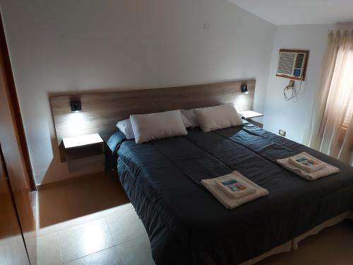 una camera da letto con un grande letto con due cuscini sopra di Aire Serrano ad Alta Gracia