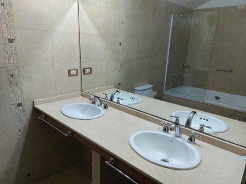 a bathroom with two sinks and a large mirror at Aire Serrano in Alta Gracia
