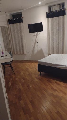 1 dormitorio con 1 cama y suelo de madera en Flat na 16 de março, centro Historico de Petropolis, en Petrópolis