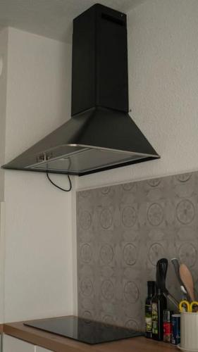 a black hood over a stove in a kitchen at Studio Ouistreham entre centre-ville et plages in Ouistreham