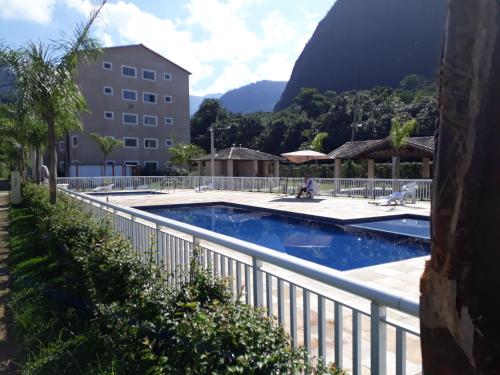 une piscine avec une clôture à côté d'un bâtiment dans l'établissement Linda casa em Condomínio no Sahy, à Mangaratiba