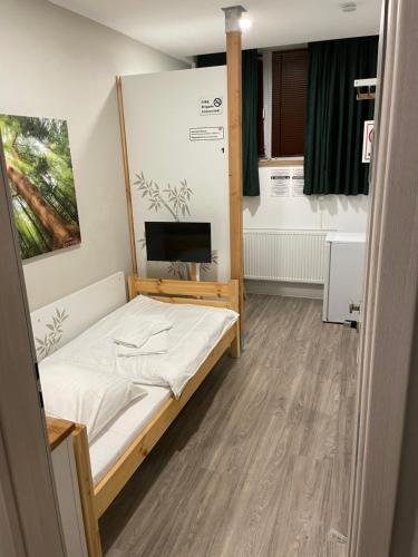 Habitación pequeña con cama y TV. en Hostel-Centrum en Hamburgo