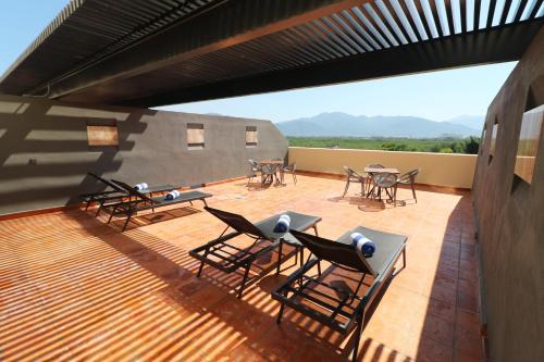 een patio met tafels en stoelen op een dak bij Holiday Inn & Suites - Puerto Vallarta Marina & Golf, an IHG Hotel in Puerto Vallarta