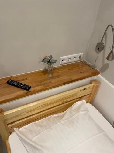 a bedroom with a wooden table with a bed and a remote control at Hostel-Centrum in Hamburg