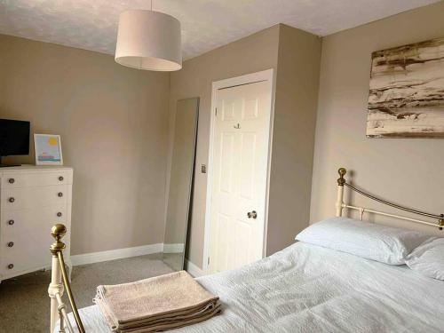a bedroom with a white bed and a white dresser at Mews house 5 minutes walk from the sea in Cleethorpes