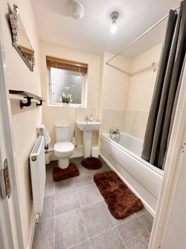 a bathroom with a toilet and a sink and a tub at JOSIS Homes in Wolverhampton