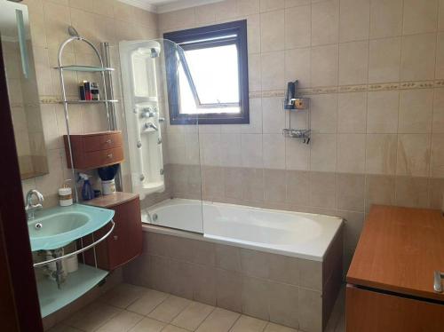 a bathroom with a bath tub and a sink at Santy in Larnaca