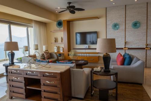 a living room with a couch and a tv at Garza Blanca Condo in Puerto Vallarta