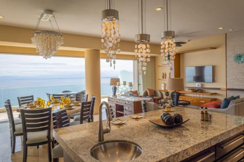 a kitchen and living room with a view of the ocean at Garza Blanca Condo in Puerto Vallarta