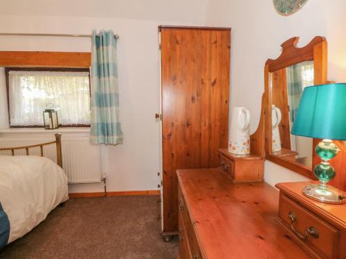 1 dormitorio con cama, espejo y tocador en Burnt Oak Stables en Mold