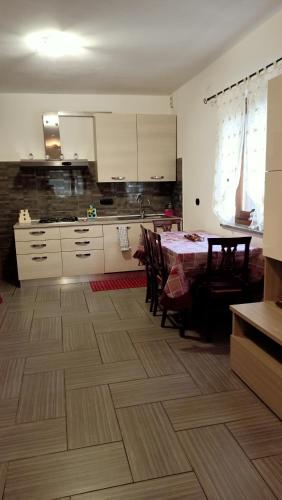 a kitchen with a table and chairs and white cabinets at da Sara in Meana di Susa