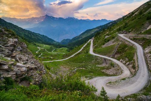 a winding road on a hill with mountains in the background at da Sara in Meana di Susa