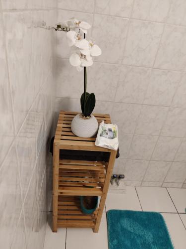 a vase with flowers on a table in a bathroom at HIBISCUS in Baillif