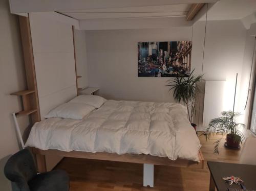 une chambre avec un lit avec un tableau sur le mur dans l'établissement Studio avec terrasse proche des transports., à Issy-les-Moulineaux