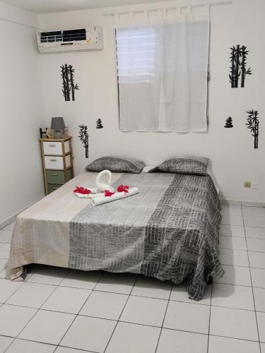 a bedroom with a bed with a tray with flowers on it at HIBISCUS in Baillif