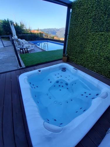 a jacuzzi tub on a deck next to a pool at Casa dos Mirandas in Vieira do Minho
