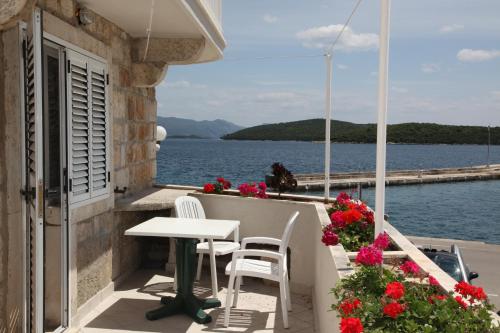 a table and chairs on a balcony overlooking the water at Apartments Luka, Punta Jurana in Korčula