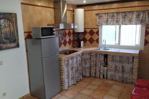 a kitchen with a refrigerator and a microwave at La Casa de los Patos in Toledo