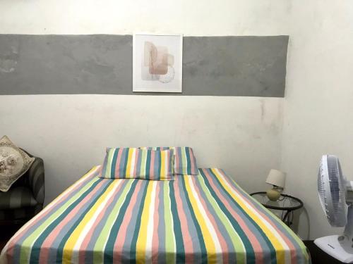 a bedroom with a bed with a colorful striped sheets at Pousada Cisne Branco in Natal