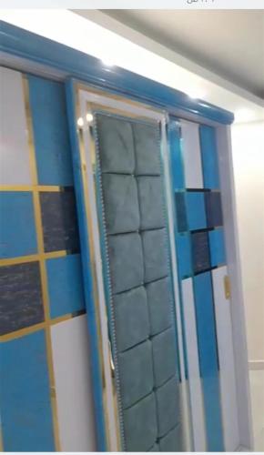 espejo en el baño con azulejos azules y blancos en شقق فاخرة في المهندسين بالقاهره بكافة الخدمات, en El Cairo