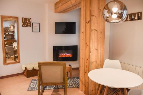 a living room with a table and a fireplace at Envalira Vacances - Woody in Pas de la Casa