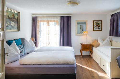 a hotel room with two beds and a window at Villa Daringer in Mayrhofen