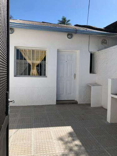 Casa blanca con puerta y ventana en Rugidor Alojamientos en Corrientes