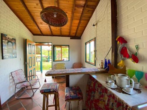 Habitación con cocina con encimera y sillas. en Cabaña Alcaravanes., en San Vicente de Chucurí