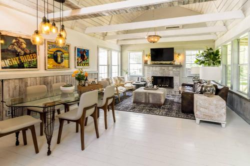a living room with a dining table and a fireplace at Happiness Ranch - Pecan Tree House in Blanco