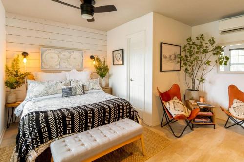 a bedroom with a bed and two chairs at Happiness Ranch - Pecan Tree House in Blanco