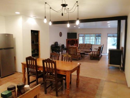 cocina y sala de estar con mesa de madera y sillas en Hostal Font´s en Areponapuchi