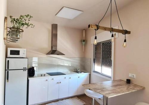 cocina con nevera blanca y mesa en Casita del Río Ourense, en Ourense