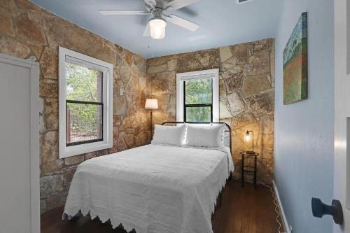 a bedroom with a bed with a stone wall at Milk Bath Springs Cottage in Dripping Springs