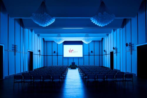 an empty room with a screen and chairs in it at Virgin Hotels Dallas in Dallas