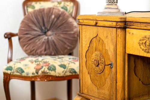 a wooden cabinet with a chair next to a table at Villa Daringer in Mayrhofen