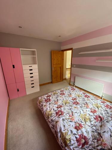 1 dormitorio con 1 cama y paredes rosas y moradas en Town villa with charming garden, bbq area & Sleeps 6, en Cashel
