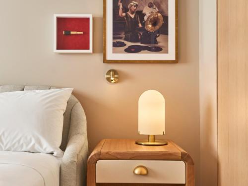 a bedroom with a bed and a table with a lamp at Virgin Hotels Dallas in Dallas