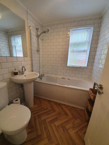 a bathroom with a toilet and a tub and a sink at Jaw-Dropping Lodge with Hot Tub on Lake Windermere in Windermere