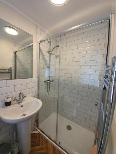 a bathroom with a shower and a sink and a shower at Jaw-Dropping Lodge with Hot Tub on Lake Windermere in Windermere