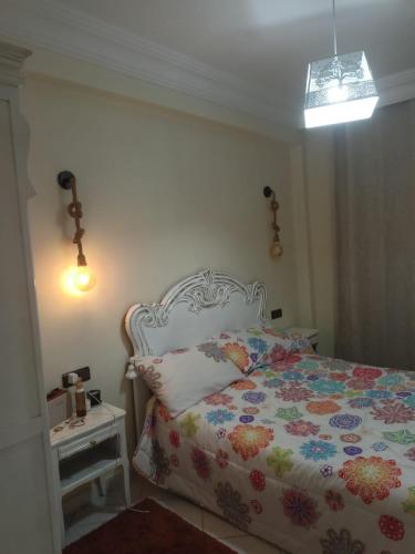 a bedroom with a bed with a floral bedspread at Appartement au Coeur de Casablanca in Casablanca