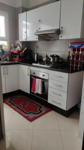 a kitchen with white cabinets and a stove top oven at Appartement au Coeur de Casablanca in Casablanca