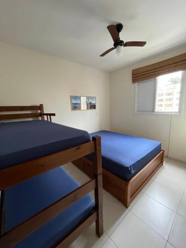 een slaapkamer met 2 stapelbedden en een plafondventilator bij Apt 2 suites com ar condicionado e piscina Ubatuba in Ubatuba